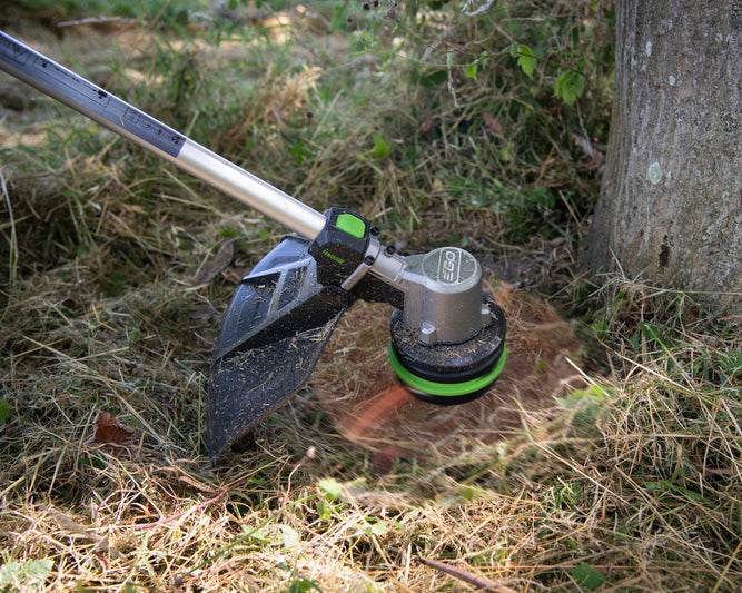 EGO ST1510E-T Freischneider schneidet am Baum Gras weg